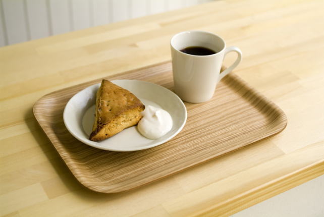 机の上のお盆に、軽食として置かれた、三角のパンとホップクリームとコーヒー。